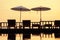 Terrace with a view on sea and sunset. Umbrellas and lounge chair in a sunlight