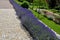 Terraces with stairs in a sloping park. stone retaining walls with light stone. blue lavender and pink roses with perennials grow