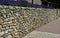 Terraces with stairs in a sloping park. stone retaining walls with light stone. blue lavender and pink roses with perennials grow