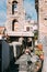 Terracina, Italy. Young Caucasian Woman Tourist Walking At Street Near Bell Tower Of Church Of San Giovanni