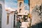 Terracina, Italy. Young Caucasian Woman Tourist Walking At Street Near Bell Tower Of Church Of San Giovanni