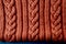 terracotta color ribbed knitted fabric pattern close up as background. Detail of the handmade knitted pattern. Brown color