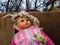 The terrible dirty doll in a pink dress lies on a sofa