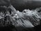 Terrible lifeless rocks, a glacier in the Alps, clouds and fog spread over the peaks of the mountains