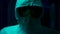 Terrible man in protective suit. Stock footage. Scary man with glasses, mask, and protective suit stands in dark. Modern