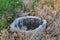 A terrible old well with unknown contents. A rotten structure of gray cement concrete, like a sewer. Round shape for descending