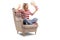 Terrified young woman with a box of popcorn sitting in an armchair