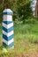 Territorial sign. Wooden green and white striped post in the fo
