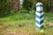 Territorial sign. Wooden green and white striped post in the fo