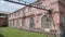 Territory of abandoned metallurgical plant with building of warehouse built with red brick.