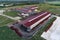 The territory of an industrial plant. Large hangars with a red roof. Aerial view, evening shooting