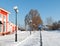 The territory of the station square in winter, cleared of snow area, pedestrian crossing lighting poles in a row