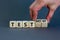 Test or testimony symbol. Businessman turns wooden cubes and changes the word `test` to `testimony`. Beautiful grey background