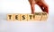 Test or testimony symbol. Businessman turns wooden cubes and changes the word `test` to `testimony`. Beautiful white backgroun