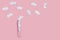 Test tube with white hearts around on pink background. Love concept