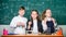 Test tubes with colorful substances. School laboratory. Group school pupils study chemical liquids. Girls and boy