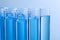 Test tubes with reagents on blue background, closeup. Laboratory analysis