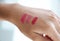 Testing color shades Lipstick on female hand cosmetics make-up