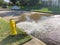 Testing yellow fire hydrant gushing water across a residential street near Dallas, Texas, USA