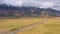 Teton Range, Meadow and Road on Autumn Cloudy Day. Wyoming, USA. Aerial View