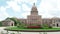 Texas State Capitol in Austin, Texas on a sunny summer day with colorful flowers in the front yard