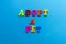 Text adopt a pet from plastic colored letters on blue paper background