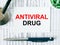 Text Antiviral Drug on the white card with the stethoscope, pen, green pills and medical documents