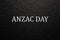 Text Anzac Day on black textured background. Anzac Day.