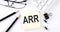 Text ARR ACCOUNTING RATE OF RETURN on the sticker with keyboard , pencils and office tools