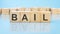 text BAIL made with wood building blocks. blue background. business concept
