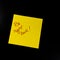 Text Be right back on sticky note. Yellow sticky note on black background