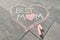 Text best mom written on gray sidewalk in crayons, mothers day