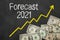 Text on blackboard with money - Forecast 2021