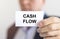 Text cash flow inscription on paper card in hands of businessman