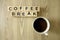 Text coffee break and cup of arabica on wooden table