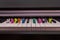 Text from colorful candles `happy birthday` on the piano keyboard.