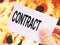 Text Contract on white card paper in a hand.