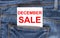 Text December Sale on white paper in the pocket of blue denim jeans