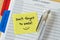 Text don`t forget to smile written on a sticky note over an agen