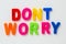 Text DONT WORRY made by magnetic letters on a white wooden background. Business Success