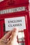 Text english classes in a signboard and a red telephone booth