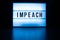 Text in english on lightbox sign spelling Impeach