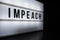 Text in english on lightbox sign spelling Impeach.