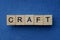 text on gray word craft in small wooden letters