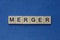 text on gray word merger in small wooden letters