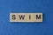 Text on gray word swim in small wooden letters