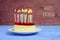 Text happy birthday and cheesecake with lighted candles