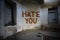 text hate you on the dirty old wall in an abandoned house