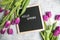 Text  Hello Spring on  letter board and bouquet of  purple Tulips flowers. Concept Springtime mood and happiness