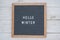 Text Hello winter on wooden letter Board in white letters on grey background